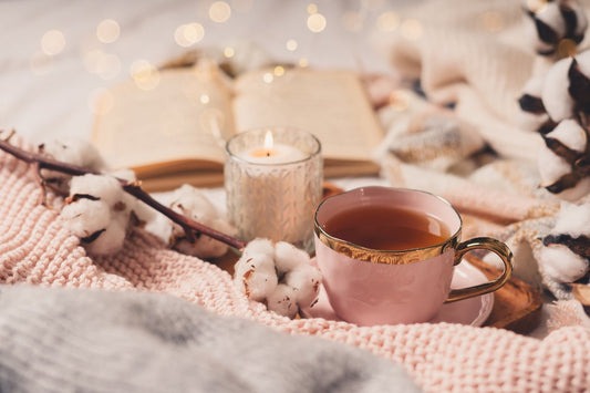 cup of tea with a scented candle in a cosy home