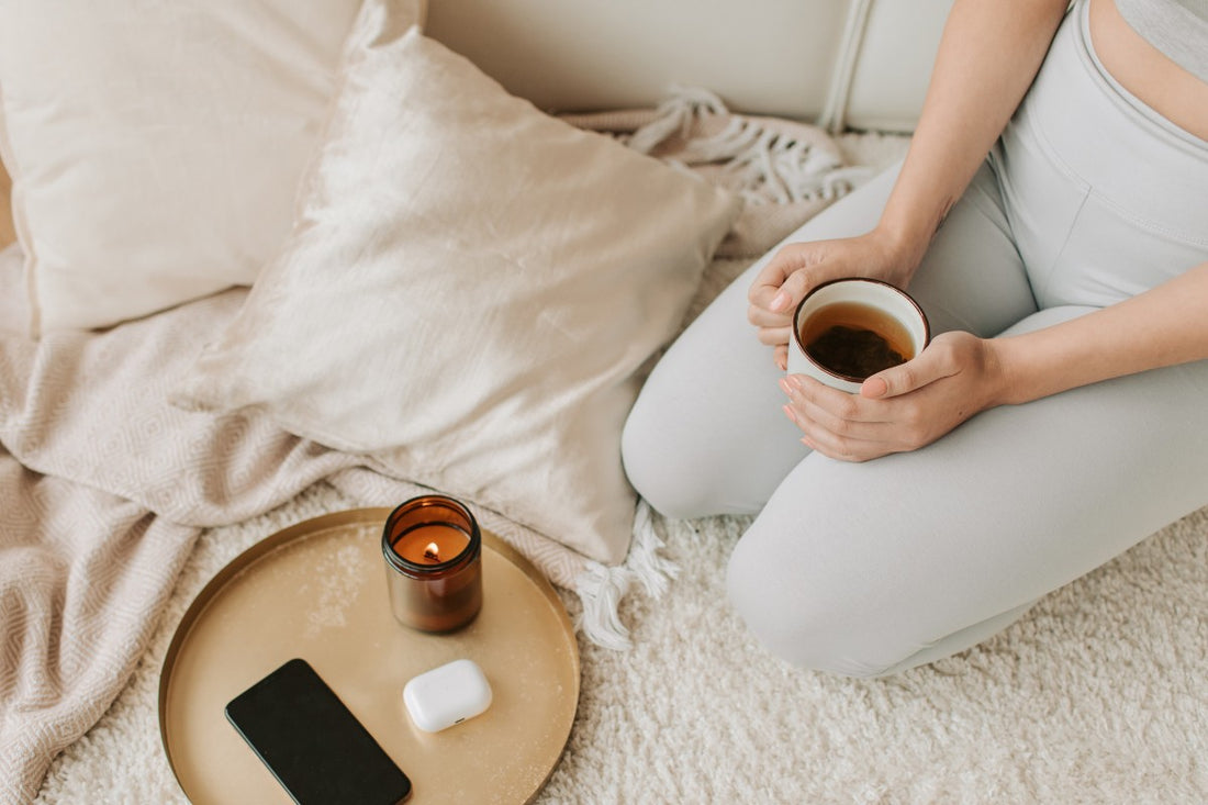woman with cup of tea and scented candle
